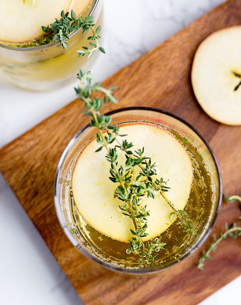 If you're having a fall or winter wedding, then you need to make this Spiked Apple Cider one of your signature cocktails. It's an upscale twist on classic apple cider, served with orange liquor, sliced apples, a sprig of rosemary and a dash of champagne for bubbles.